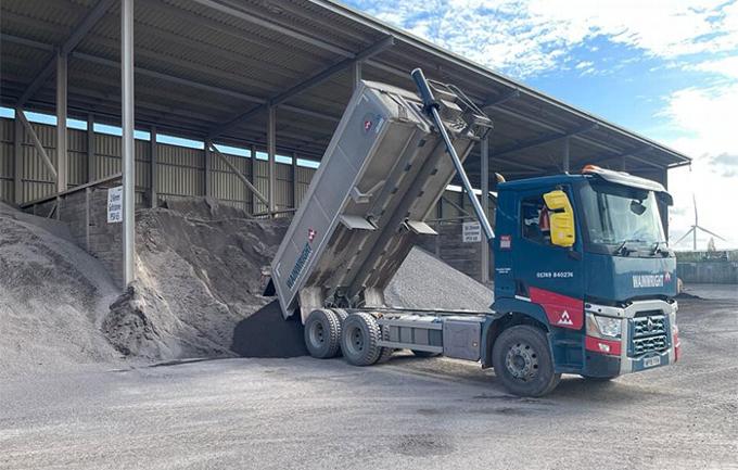 Hired out tipper truck delivering sand to yard